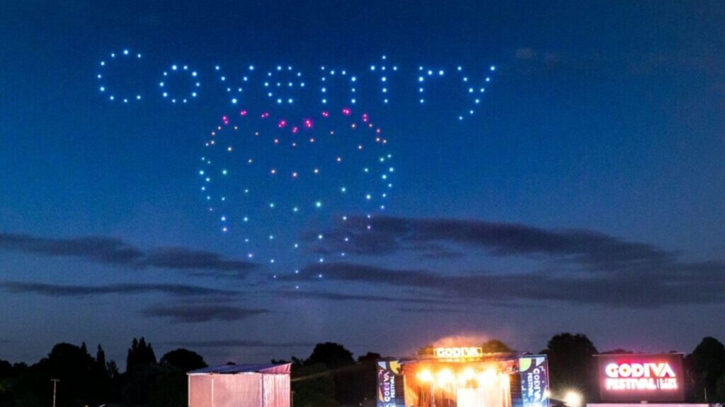 Drones form the word "Coventry" and a heart shape in lights above the Godiva Festival stage at dusk.